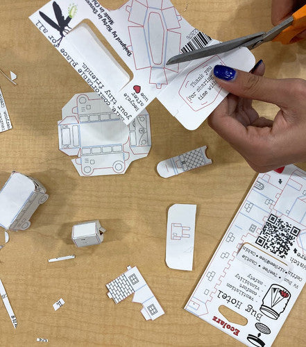 hands using scissors to cut up the bug hotel packaging into shapes