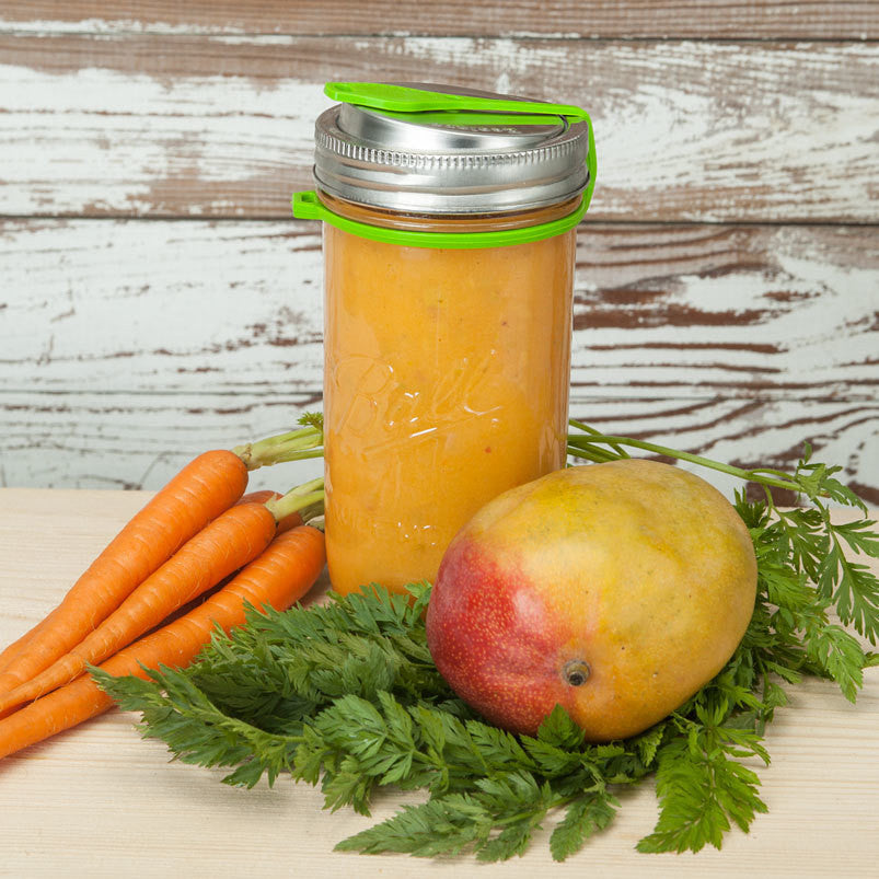 Poptop Lid with the plug closed to prevent leaking on a 24 ounce mason jar full of mango smoothie