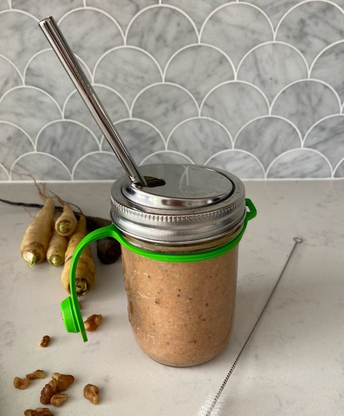 smoothie in a 16 ounce wide mouth mason jar covered with a poptop lid and a smoothie straw inside