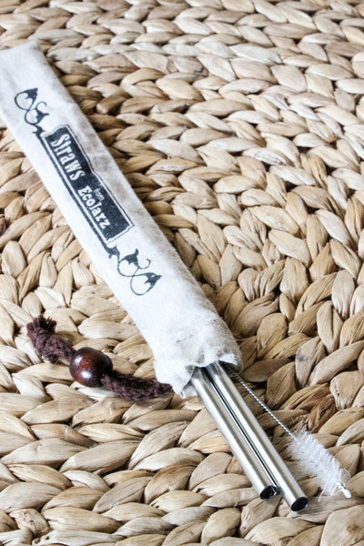 two smoothie straws and a straw cleaner in a linen bag