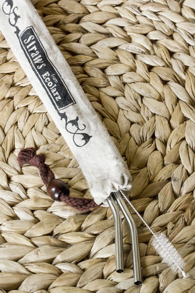 two bent straws and a straw cleaner in a linen bag